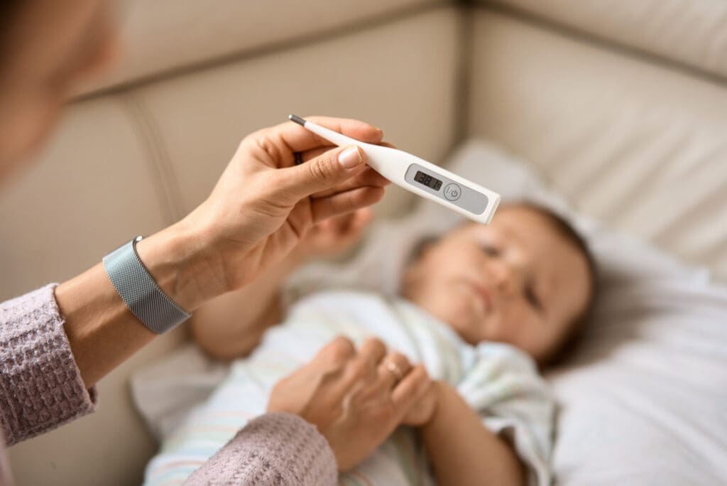 parent measuring child's temperature