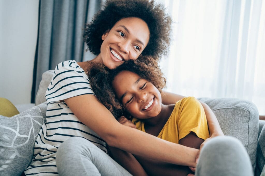mother and daughter hugging on couch