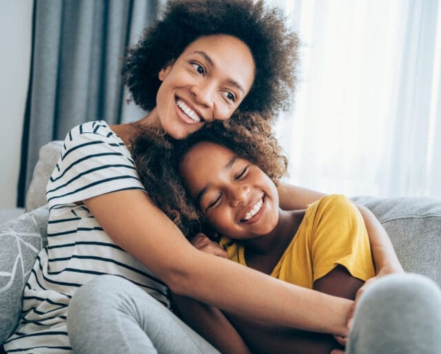 mother and daughter hugging on couch