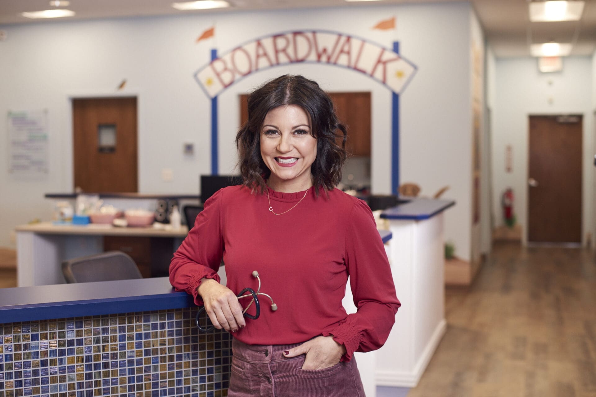 dr. christina johns standing inside a pm pediatric urgent care office.