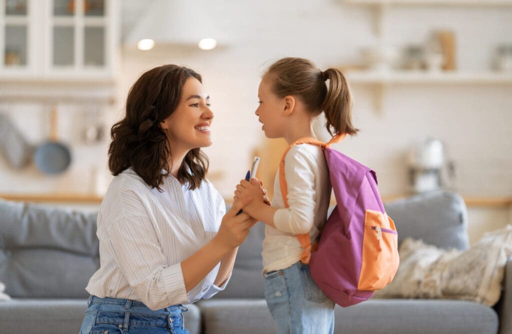 Happy family preparing for school. Little girl with mother.