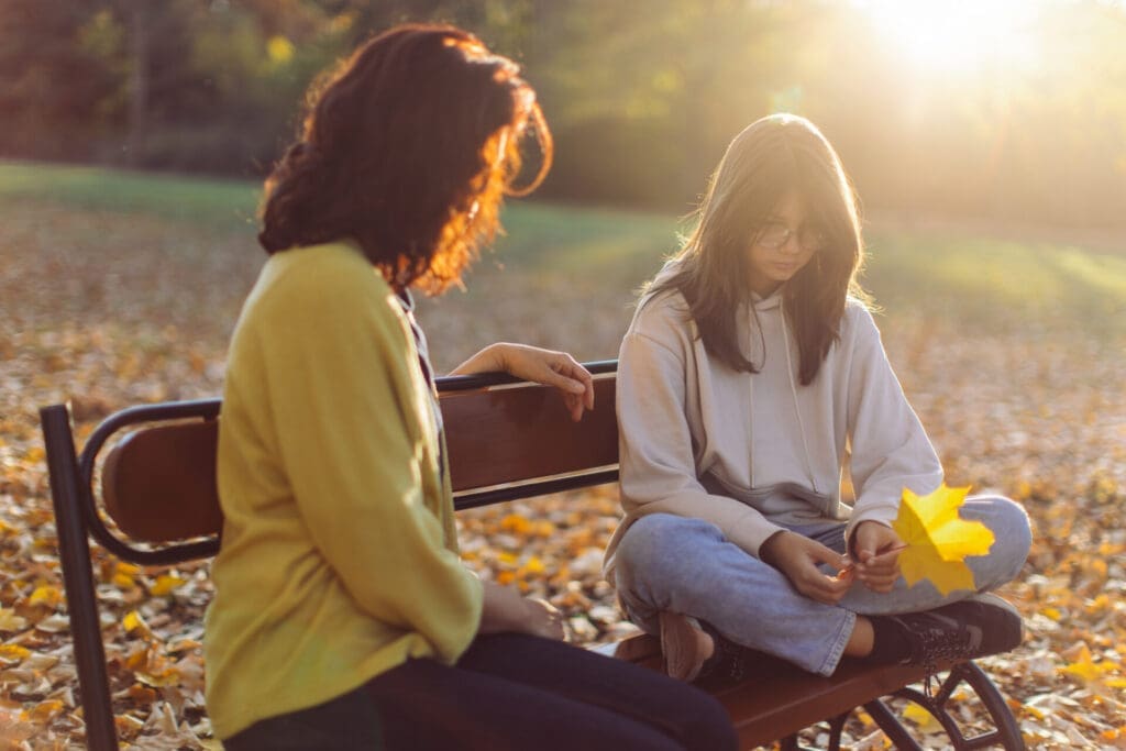 Mother and teenage daughter spending time together and mother advising her daughter who looks serious.