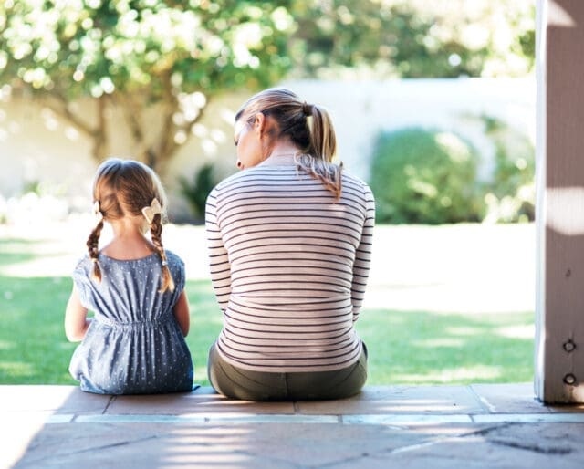 Rearview shot of a young woman and her daughter having a conversation on the porch