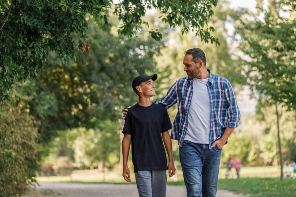 father and son walking down a road together