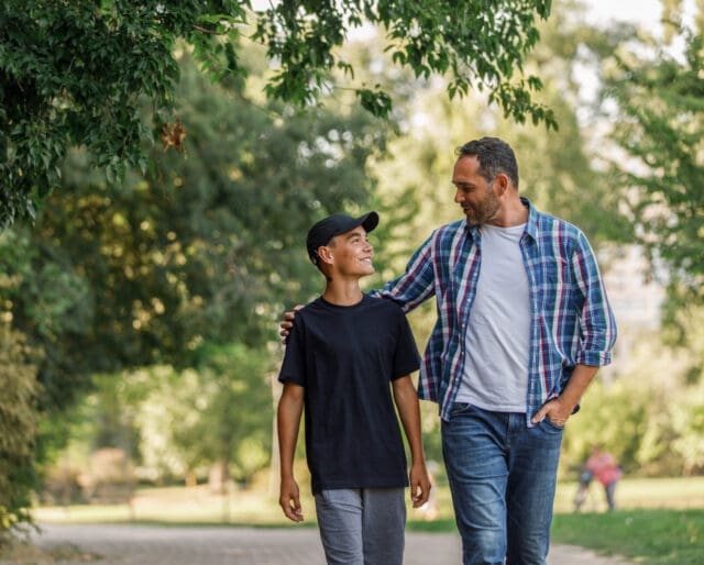 father and son walking down a road together