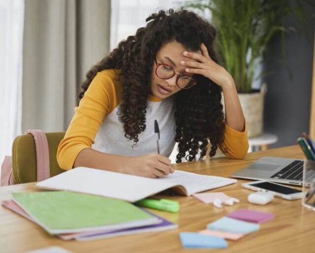 Teenage girl studying, looking stressed out