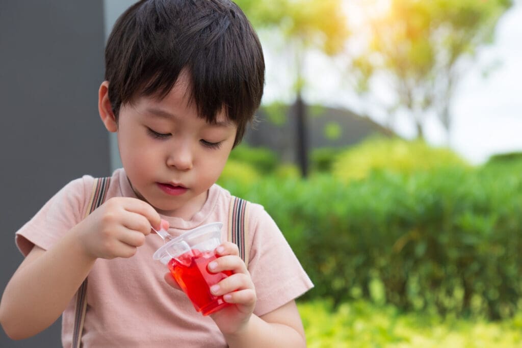 Boy eating red jello