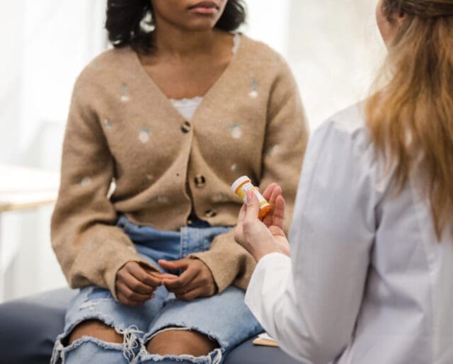 A low angle view of an unrecognizable young adult female discusses the prescription medication with the unrecognizable female doctor.