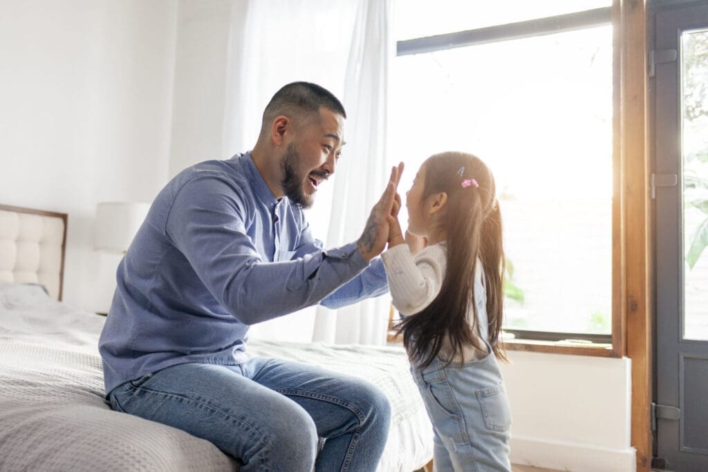 little asian girl play with dad hands and palms, korean child high five to father, happy asian family