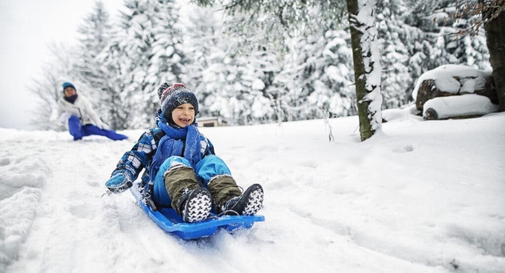 Child sledding down hill