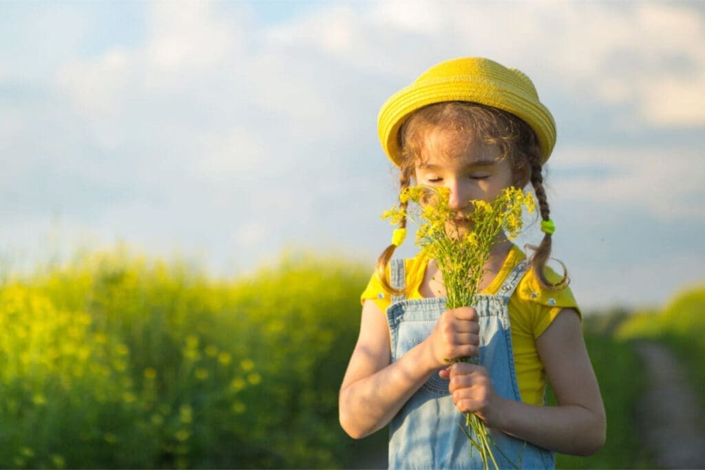 Little girl smelling flowers